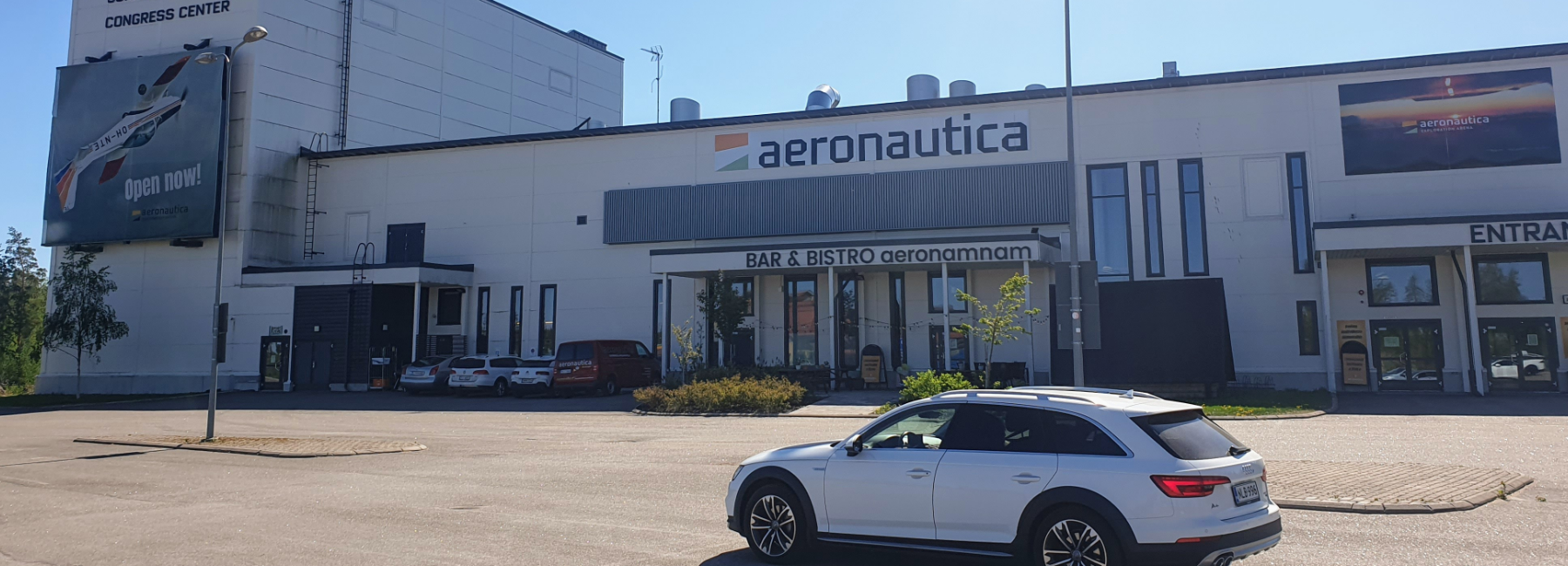 Rakennus jonka parkkipaikalla yksi auto.